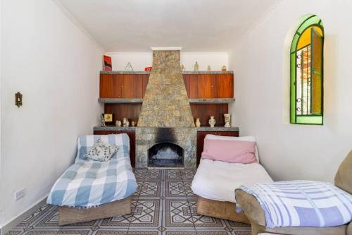 a living room with a fireplace and two chairs at Chácara dos Sonhos em Mairiporã in Mairiporã