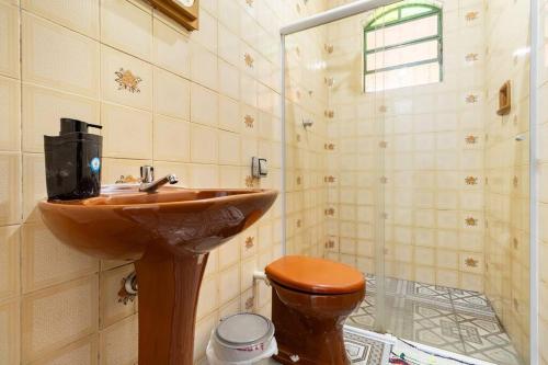 a bathroom with a wooden sink and a toilet at Chácara dos Sonhos em Mairiporã in Mairiporã