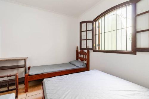a bedroom with two beds and a window at Chácara dos Sonhos em Mairiporã in Mairiporã