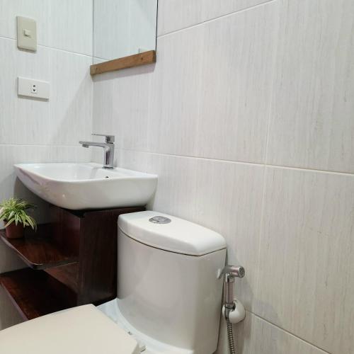 a bathroom with a toilet and a sink at Inngo Tourist Inn in El Nido
