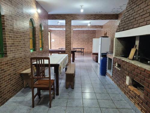 a kitchen with a table and chairs in a brick wall at Chácara dos Sonhos em Mairiporã in Mairiporã