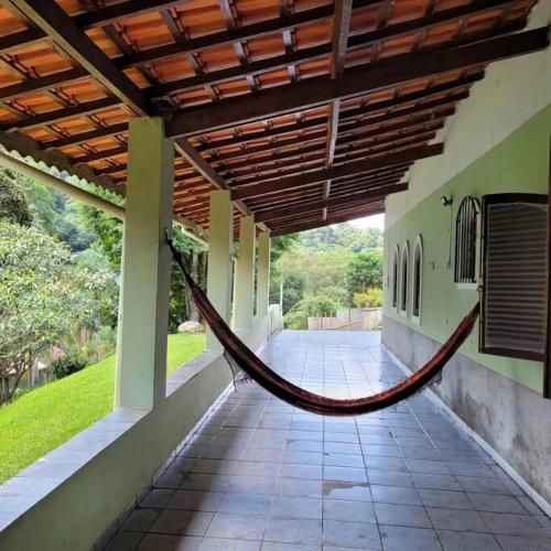 a hammock on the outside of a building at Chácara dos Sonhos em Mairiporã in Mairiporã