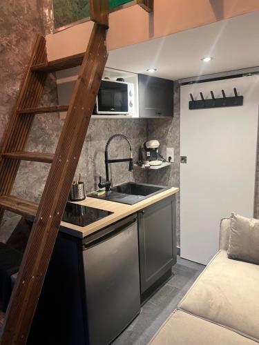 a small kitchen with a sink and a microwave at Beau-voisin 2 in Rouen