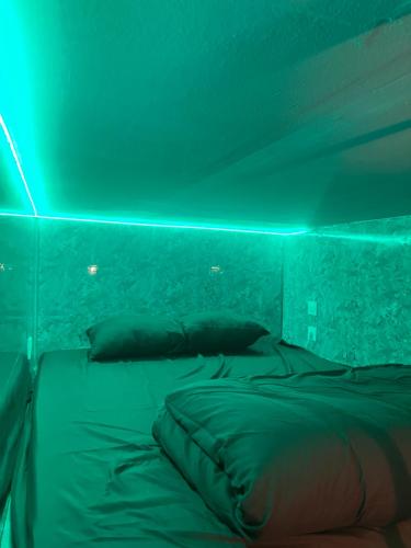 a bed in a room with green lights at Beau-voisin 2 in Rouen