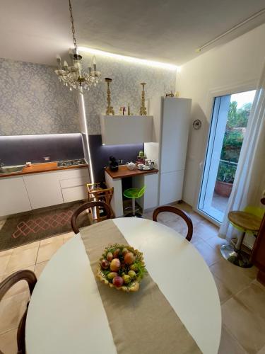 a kitchen with a table with a bowl of fruit on it at Villa Salina - Vicina al mare con giardino privato in Trabia