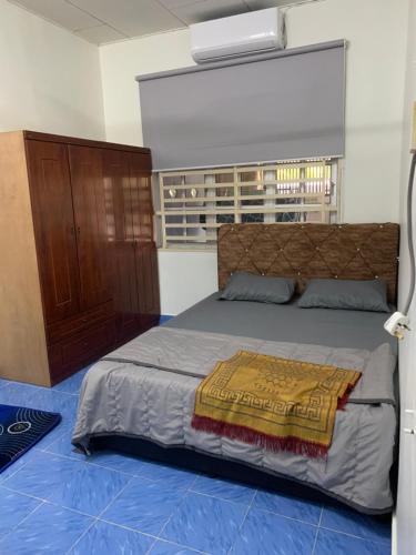 a bedroom with a large bed with a wooden headboard at Zulaika Homestay in Kampung Gurun