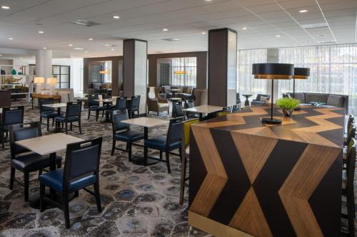 a restaurant with tables and chairs and a bar at Courtyard Miami Coral Gables in Miami