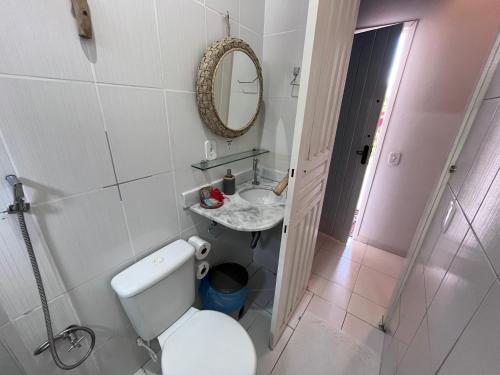 a bathroom with a toilet and a sink and a mirror at Pousada Nascente do Sol in Ilha de Boipeba