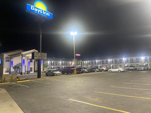 a parking lot with a drexel gas station at night at Days Inn by Wyndham El Paso West in El Paso