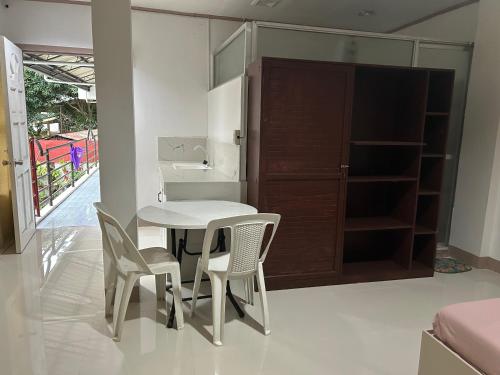 eine Küche mit einem Tisch, 2 Stühlen und einem Schrank in der Unterkunft En Pensionne Pension House in Iloilo City