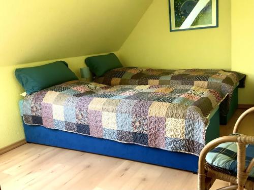 Un dormitorio con una cama con una colcha encima en FeWo 72 4, Sanddornweg 2 g, en Ostseebad Karlshagen