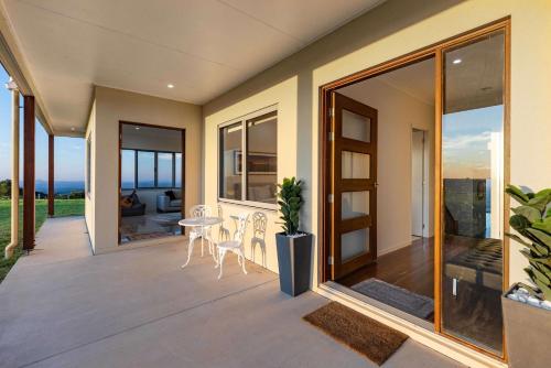 a balcony with glass doors and a table and chairs at Petrichor Estate - 360 Views Pool & Spa in Bald Knob