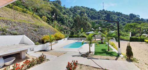 a house with a swimming pool and a mountain at HOUSE HOTEL Terra Loma in Nimaima