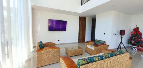 a living room with wicker furniture and a christmas tree at HOUSE HOTEL Terra Loma in Nimaima