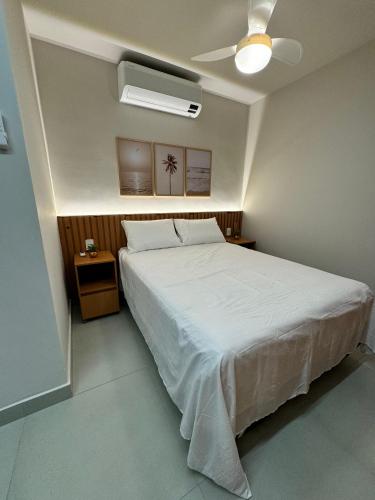ein Schlafzimmer mit einem Bett und einem Deckenventilator in der Unterkunft Flat Pé na Areia Iriri T03 - Conforto a 3 Min da Praia in Anchieta