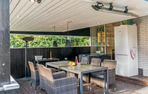a patio with a table and chairs and a refrigerator at Three-Bedroom Holiday Home In Vaggerlose in Marielyst