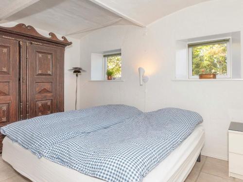 a bedroom with a bed with a blue and white checked blanket at Charming Farmhouse Retreat - By Traum Ferienwohnungen in Frederikshavn