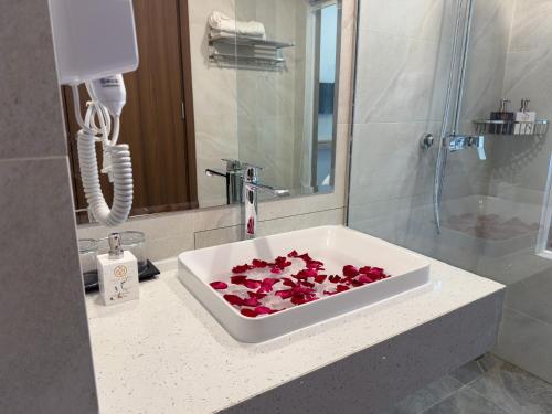 a bathroom with a sink with red roses in it at Villa Oasis in Luang Prabang