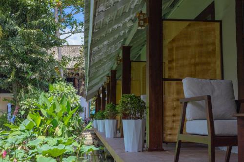 a chair sitting on a porch with plants at Villa Oasis in Luang Prabang
