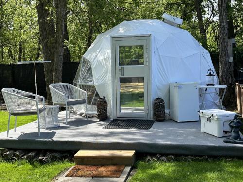 a yurt with a door and chairs and a refrigerator at Stay549 in Winnipeg