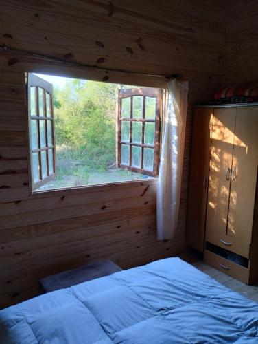 a bedroom with a large window in a log cabin at Isla Curubica Premium in Tigre
