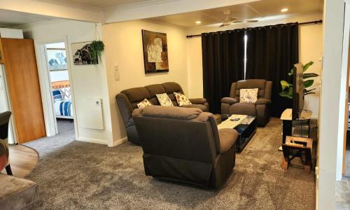 a living room with two chairs and a couch at Ahuriri Escape - Home Away Home, Entire Bungalow in Napier