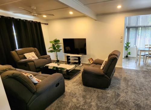 a living room with two couches and a flat screen tv at Ahuriri Escape - Home Away Home, Entire Bungalow in Napier