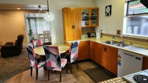 a kitchen with a table and chairs and a sink at Ahuriri Escape - Home Away Home, Entire Bungalow in Napier