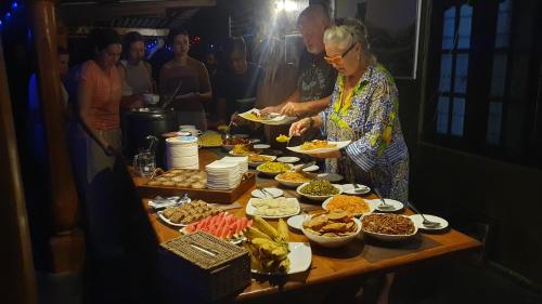 a group of people standing around a table with food at Ceylon Resort Wilpattu in Wilpattu
