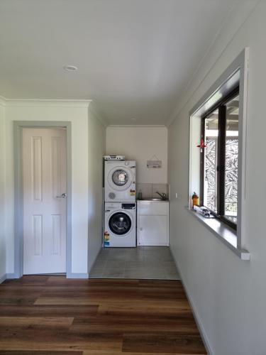 a laundry room with a washer and dryer next to a door at Millhouse on Pine in Pemberton