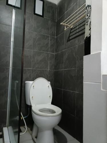 a bathroom with a white toilet in a room at Lombok Sunset Hideaway in Lembar