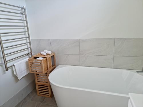 a bathroom with a tub and a toilet and a sink at Millhouse on Pine in Pemberton