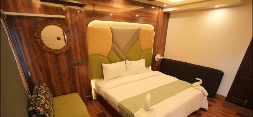 a small room with a bed and a mirror at Victoria Houseboats in Alleppey