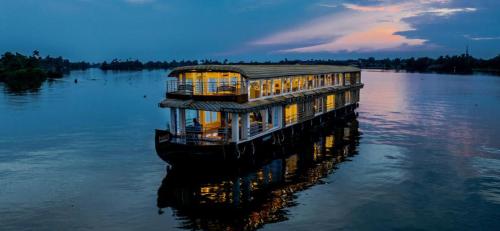 a building in the middle of a body of water at Victoria Houseboats in Alleppey