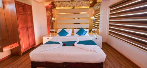 a bedroom with a bed with blue pillows at Victoria Houseboats in Alleppey