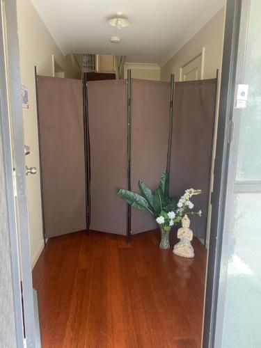 a room with a partition with a vase of flowers and a plant at Private room with ensuite and parking close to Wollongong CBD in Wollongong