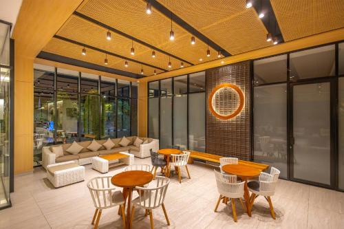 a lobby with tables and chairs and a couch at Neo Eltari Kupang by ASTON in Kupang