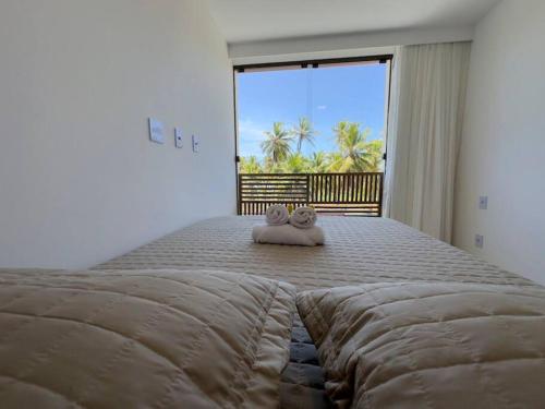 una camera da letto con un letto grande con sopra due animali di peluche di Village 2qts, frente e vista mar, praia de Imbassaí a Imbassai