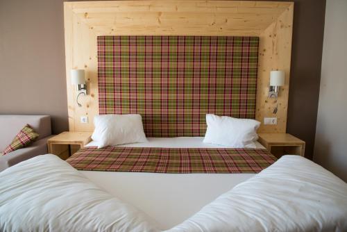 a bedroom with two beds and a plaid wall at Boutique Hotel Erla in Stubenberg