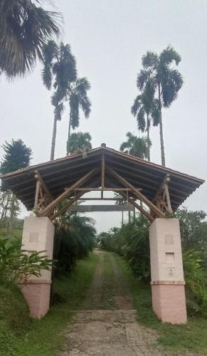 a wooden bridge over a dirt road with palm trees at My Paradise Tamesis in Támesis
