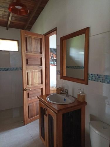 a bathroom with a sink and a mirror and a toilet at My Paradise Tamesis in Támesis