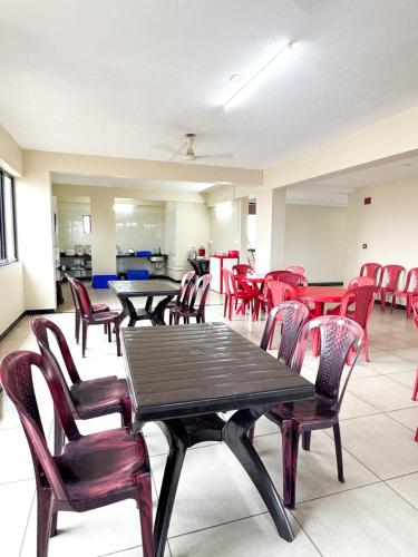 a room filled with tables and chairs with red chairs at Venkys stay inn in Udupi