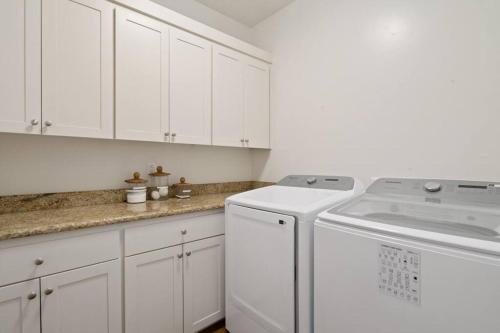 a kitchen with white cabinets and a washer and dryer at Retreat, Zion view, Hot Tub, RV Parking, 27 miles Zion in Apple Valley