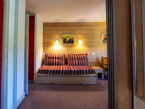 une chambre avec un lit avec deux oreillers dessus dans l'établissement Studio ensoleillé à La Plagne avec balcon et parking - FR-1-351-249, à La Plagne Tarentaise