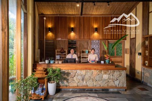 two women sitting at a counter in a restaurant at Bakhan Village Resort in Mai Chau