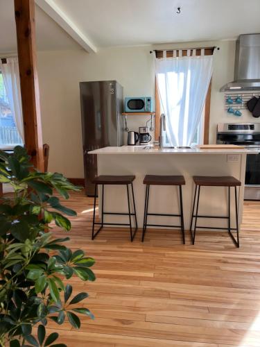 a kitchen with a counter and two stools at Retro-chic retreat in the heart of Wakefield in Wakefield