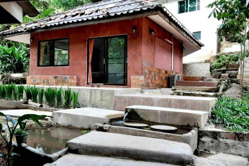 a small red house with a pond in front of it at The Cascade - Mae Taeng Waterfall Bungalows in Ban Mae Ta Man (1)