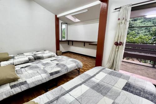 two beds in a room with a window at The Cascade - Mae Taeng Waterfall Bungalows in Ban Mae Ta Man (1)