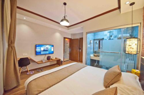 a bedroom with a large bed and a bathroom at XiXi Lakeside Inn in Guilin