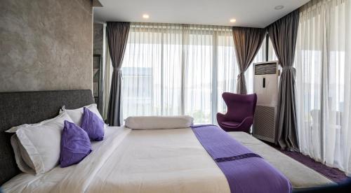 a hotel room with a large bed with purple pillows at Anh Nguyen Oceanfront Luxury Villas Nha Trang in Nha Trang